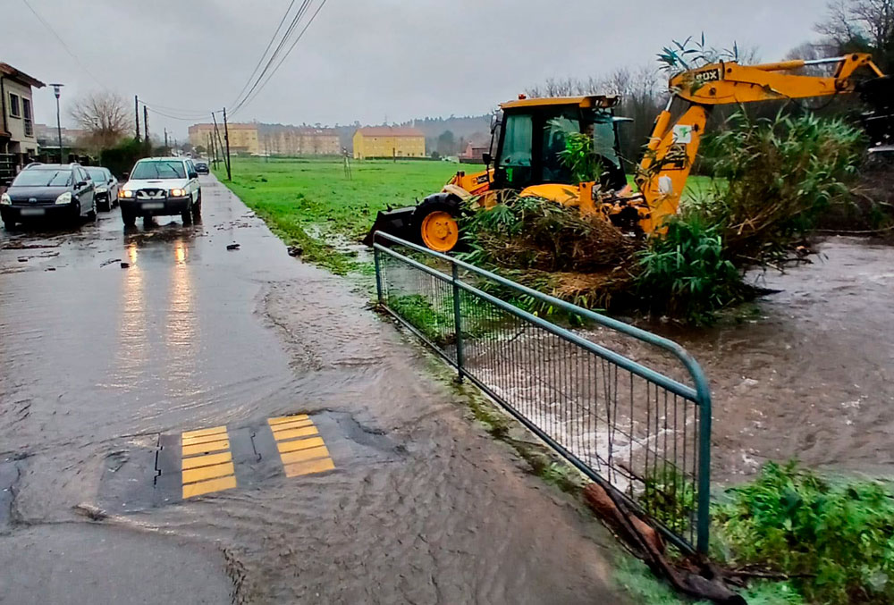 Imaxe da maquinaria municipal traballando á beira dunha canle de drenaxe